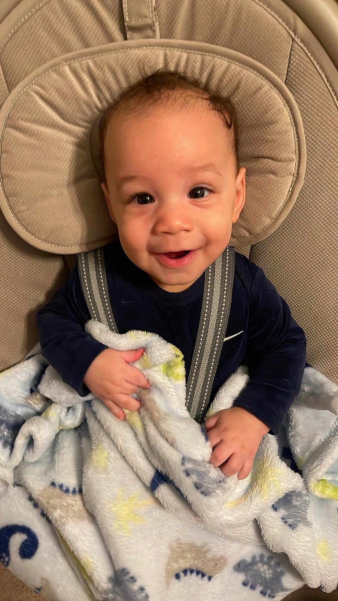 Elias is registered to the contest to win money with this photo: baby, smiling, blanket, baby_seat, child, happy, face, infant, cozy, comfort, cute, clothing, indoor, person, seatbelt, soft, patterned_blanket, portrait, young_child, sitting