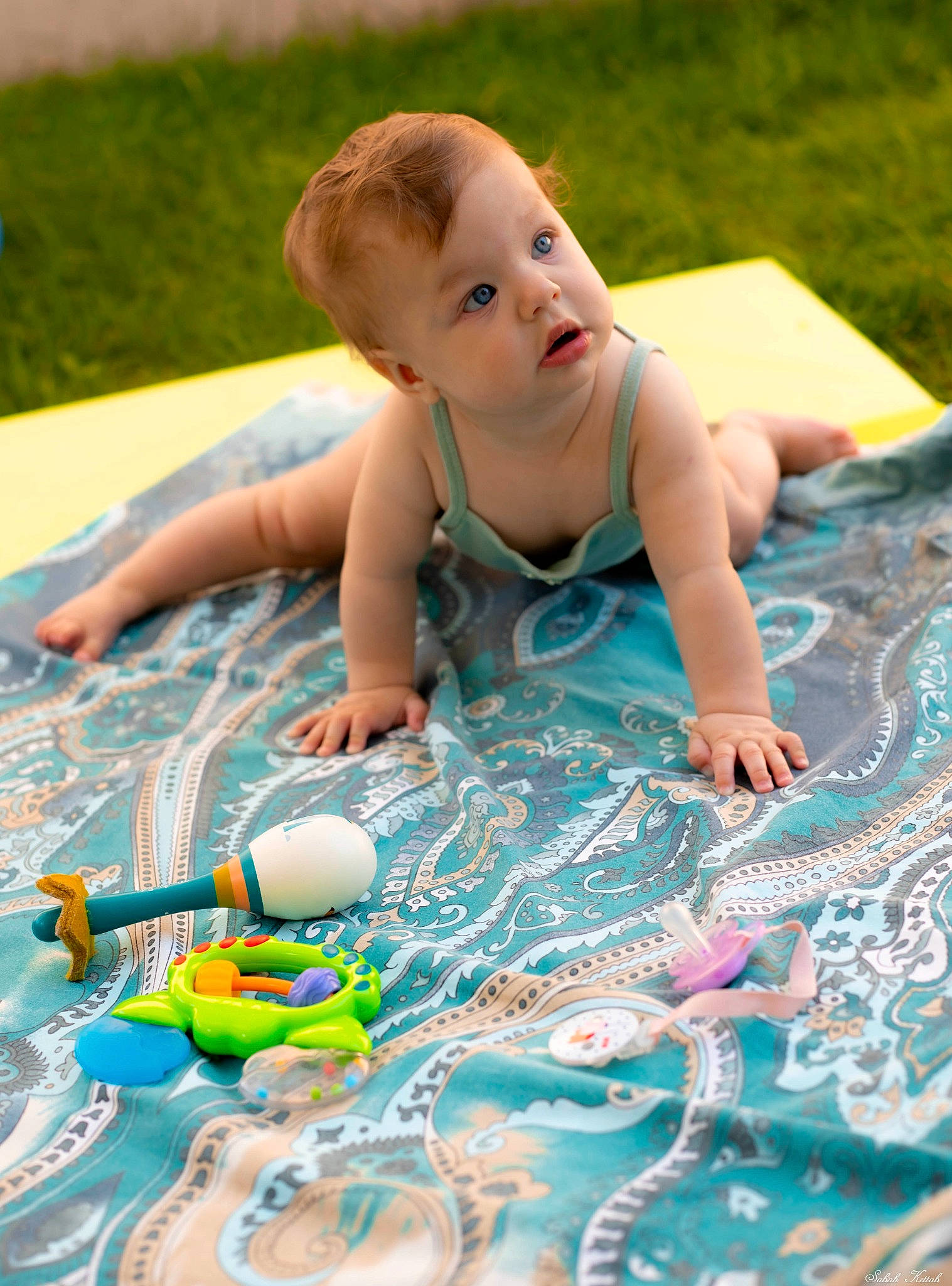 Nuria a rejoint le concours — aidez-le/la à gagner de superbes lots ! azure, baby, baby_toddler_clothing, child, event, flooring, fun, grass, happy, leisure, mammal, pattern, people_in_nature, person, product, recreation, sitting, smile, summer, surprise