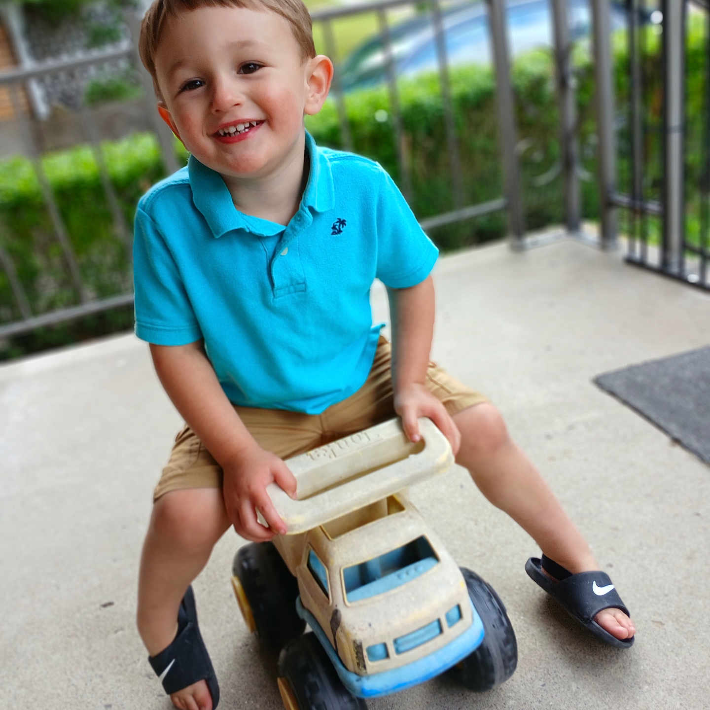 Chevy joined the competition — help win amazing prizes! blue_shirt, boy, casual_clothing, child, concrete_floor, cute, daylight, footwear, greenery, happy, outdoor, plastic_toy, playing, porch, portrait, railing, shorts, smiling, summer, toy_truck