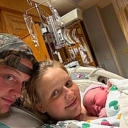 Isabella joined the competition — help win amazing prizes! hospital, newborn, baby, mother, father, family, medical, iv_drip, baby_blanket, hospital_bed, parent, child, smile, cap, gown, indoor, celebration, healthcare, together, love
