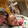 hospital, newborn, baby, mother, father, family, medical, iv_drip, baby_blanket, hospital_bed, parent, child, smile, cap, gown, indoor, celebration, healthcare, together, love