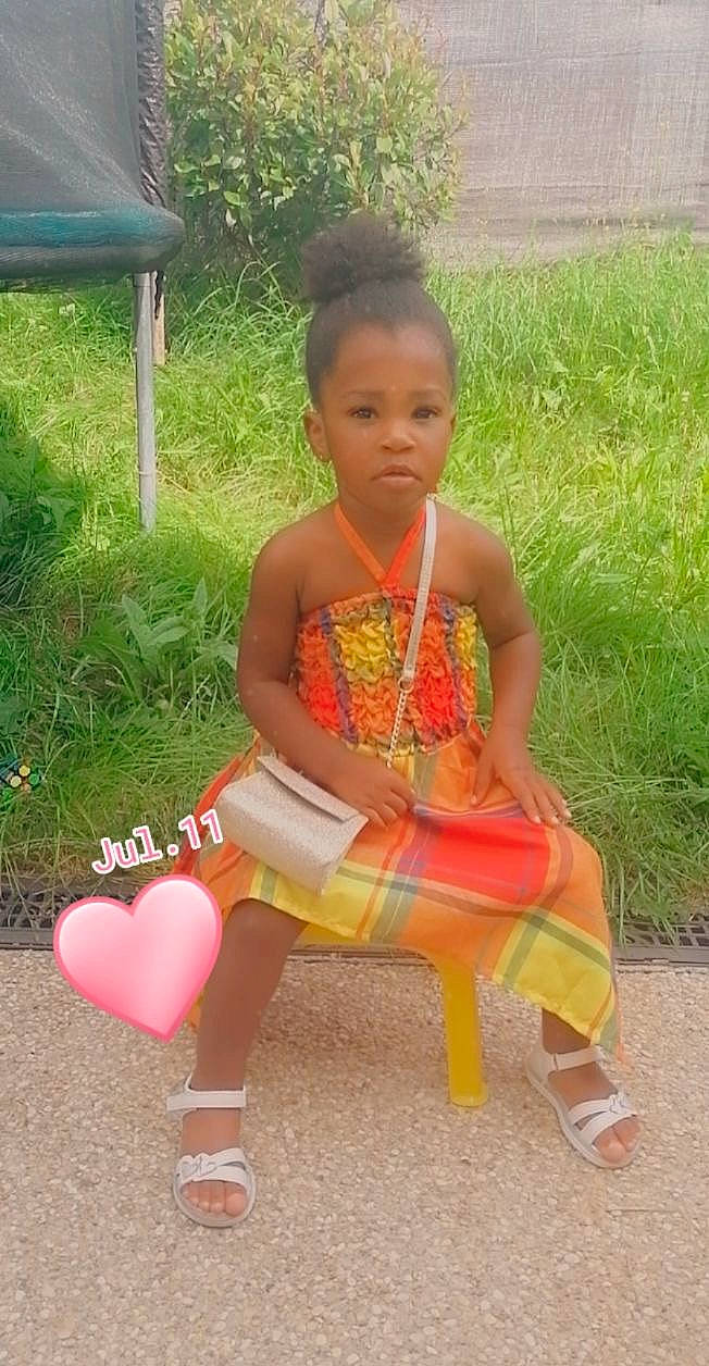 Shayana participe au concours pour gagner de l'argent avec cette photo : baby_toddler_clothing, barefoot, child, face, fun, grass, hair, happy, head, human_body, human_leg, jewellery, lap, leisure, magenta, person, play, sandal, sitting, thigh