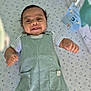 baby, smiling, overalls, striped_shirt, lying_down, nursery, star_pattern, blanket, mobile_toys, pastel_colors, happy, infant, cute, playful, child, indoors, soft_lighting, portrait, small_hands, cheerful