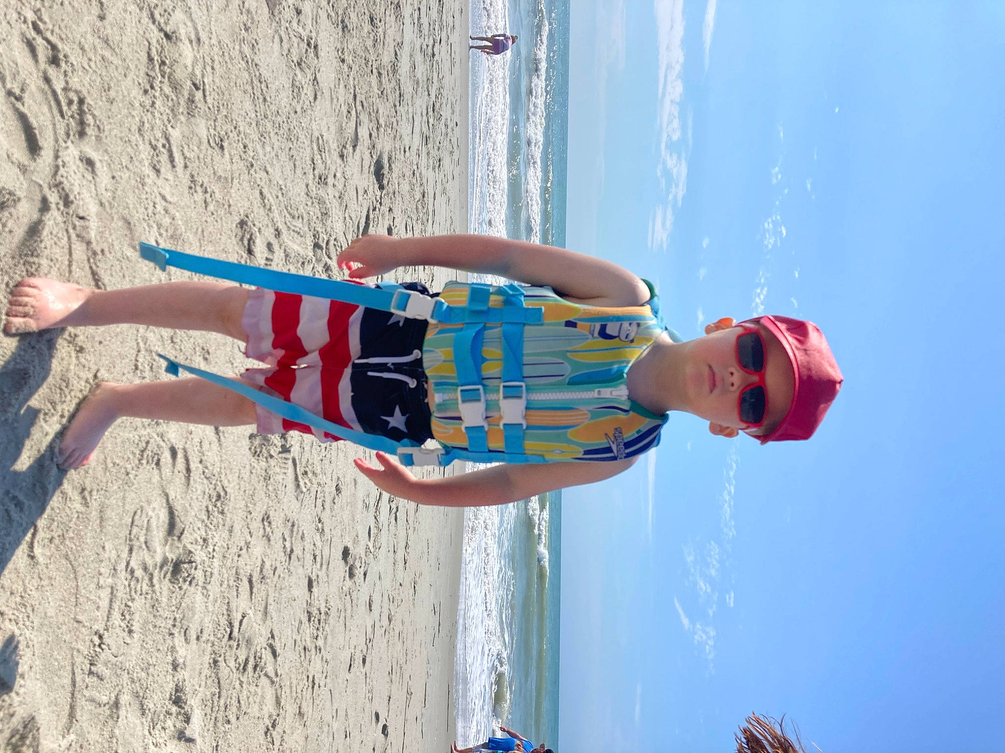 Bentley is registered to the contest to win money with this photo: azure, beach, blue, boats_and_boating_equipment_and_supplies, elbow, electric_blue, eyewear, fun, happy, headwear, human_leg, leisure, ocean, people_on_beach, person, recreation, sand, sky, thigh, travel