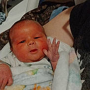 Sebastian is registered to the contest to win money with this photo: baby, newborn, blanket, hand, face, person, hospital, bed, comfort, sleepy, infant, cute, soft, skin, portrait, clothing, lying_down, rest, new_life, care