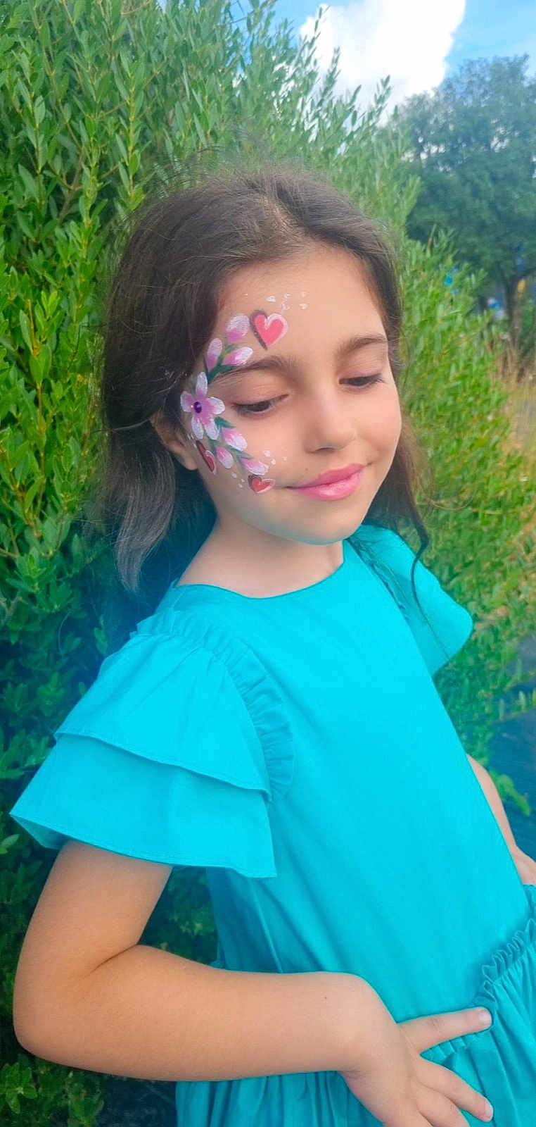 Adriana participe au concours pour gagner de l'argent avec cette photo : child, girl, face_paint, flower_paint, heart_paint, blue_dress, outdoor, greenery, smile, portrait, nature, summer, happy, young, cute, fashion, beauty, skin, person, posing
