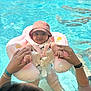 Lya a rejoint le concours — aidez-le/la à gagner de superbes lots ! baby, child, cute, float, hands, happy, holding, infant, inflatable, life_vest, outdoor, parent, pink_hat, pool, safety, smiling, summer, sunhat, swimming, water