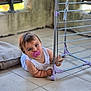 Santino a rejoint le concours — aidez-le/la à gagner de superbes lots ! baby, pacifier, floor, tile, metal, drying_rack, cushion, indoor, child, white_clothing, hand, face, expression, grip, light, wall, window, young_child, curious, crawling