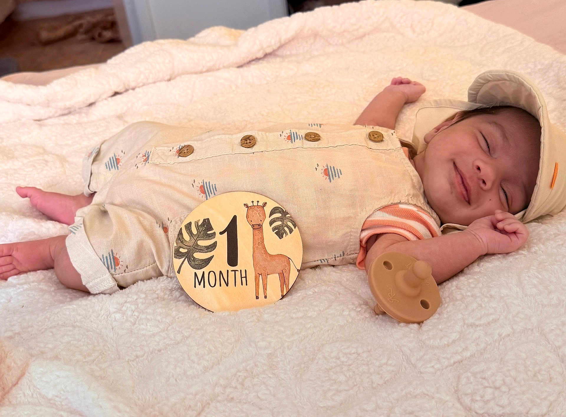 Audi joined the competition — help win amazing prizes! baby, infant, smiling, sleeping, blanket, pacifier, clothing, hat, wooden_sign, giraffe, one_month, cute, resting, newborn, soft_texture, indoor, portrait, milestone, child, peaceful