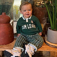 Orso participe au concours pour gagner de l'argent avec cette photo : child, toddler, boy, smiling, green_sweater, striped_pants, sneakers, plant, terracotta_vase, wooden_bench, indoor, portrait, face, cheeks, hair, eyes, casual_clothing, pottery, houseplant, comfortable
