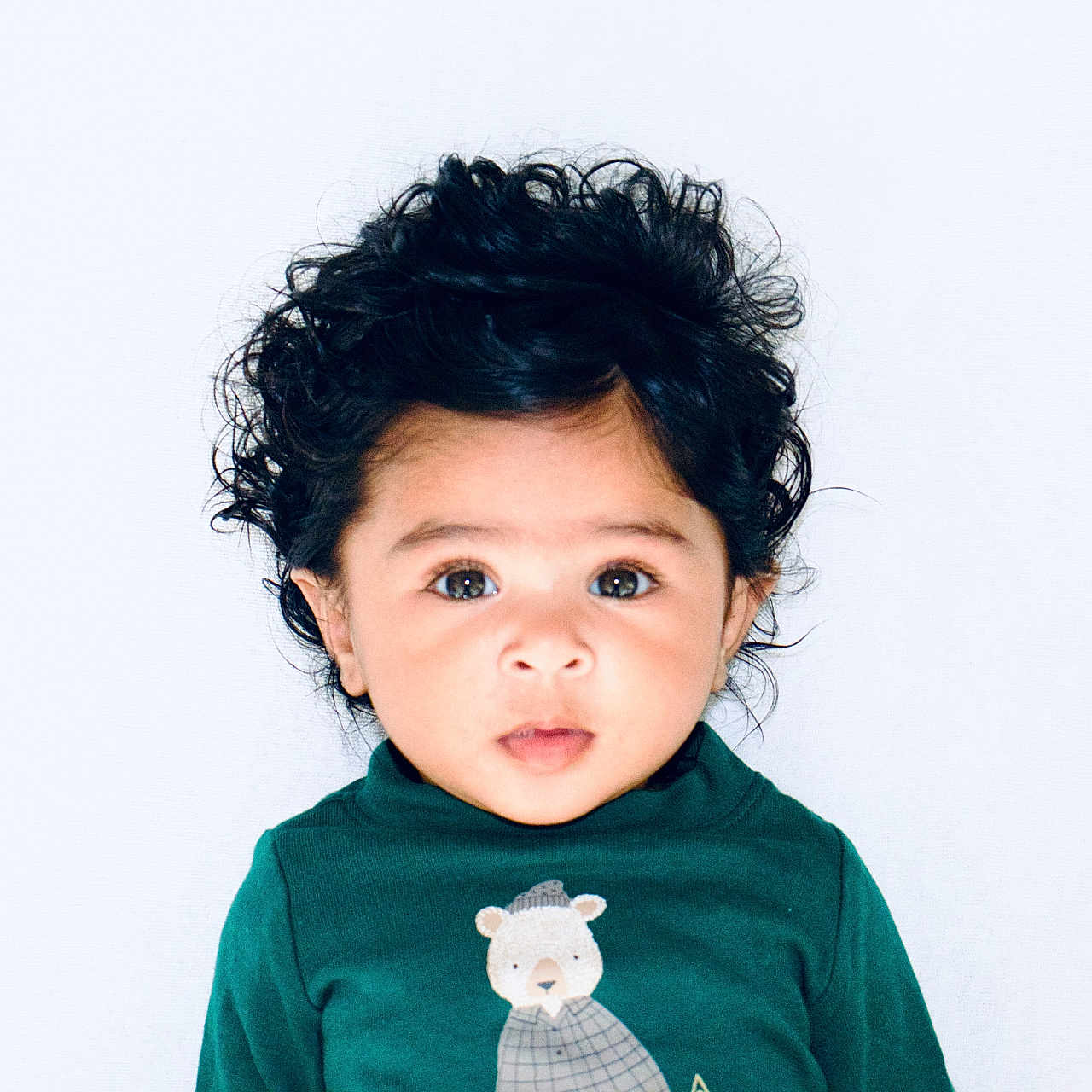 Swaha joined the competition — help win amazing prizes! baby, bear_illustration, child, clothing, curly_hair, cute, expression, eyes, face, green_shirt, headshot, indoor, innocence, looking_at_camera, person, portrait, studio_photo, toddler, white_background, young_child