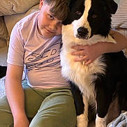 Arès participe au concours pour gagner de l'argent avec cette photo : animal, black_and_white, blanket, casual_clothing, child, child_hugging_dog, comfort, companion, couch, cute, dog, friendship, furniture, home, hugging, indoor, pet, pillow, relaxed, seated