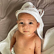Gumatz joined the competition — help win amazing prizes! baby, infant, towel, diaper, bed, blanket, cute, face, eyes, skin, headwear, soft, expression, child, laying, indoors, person, newborn, toddler, portrait