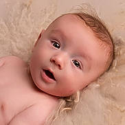 Louie is registered to the contest to win money with this photo: baby, blanket, child, closeup, curious, expression, eyes, face, hair, head, indoors, infant, lying_down, mouth, naked, newborn, portrait, skin, soft_texture, young_child