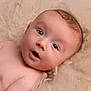Louie is registered to the contest to win money with this photo: baby, blanket, child, closeup, curious, expression, eyes, face, hair, head, indoors, infant, lying_down, mouth, naked, newborn, portrait, skin, soft_texture, young_child