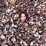 child, face, leaves, autumn, fall, outdoor, nature, curly_hair, playful, camouflage, seasonal, brown, red, orange, tree, foliage, cute, smiling, young, park