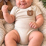 Amir is registered to the contest to win money with this photo: baby, infant, child, smiling, portrait, lying_down, teddy_bear, stuffed_animal, blanket, fluffy_blanket, onesie, sandals, wooden_sign, nursery, cozy, indoor, close_up, happy, brown_tones, baby_photography