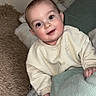 baby, child, smiling, face, eyes, blanket, cushion, pillow, cozy, indoors, sitting, clothing, sweater, soft, cute, happy, portrait, infant, person, home