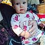 Ara is registered to the contest to win money with this photo: toddler, child, person, indoor, floral_dress, hand, face, eyes, curly_hair, clothing, sitting, adult, lap, casual, portrait, cute, holding, pattern, warm_light, cozy