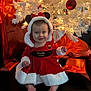 baby, child, christmas, holiday, festive, red_dress, white_fur, mouse_ears, bow, smile, lights, christmas_tree, ornaments, gifts, wrapped_presents, floor, indoors, happy, cute, portrait
