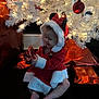 Adalee is registered to the contest to win money with this photo: baby, child, christmas_tree, holiday, gift, red_dress, white_fur_trim, mouse_ears, festive, lights, ornaments, wrapped_presents, sitting, indoor, celebration, smiling, cute, holiday_decor, toddler, joyful