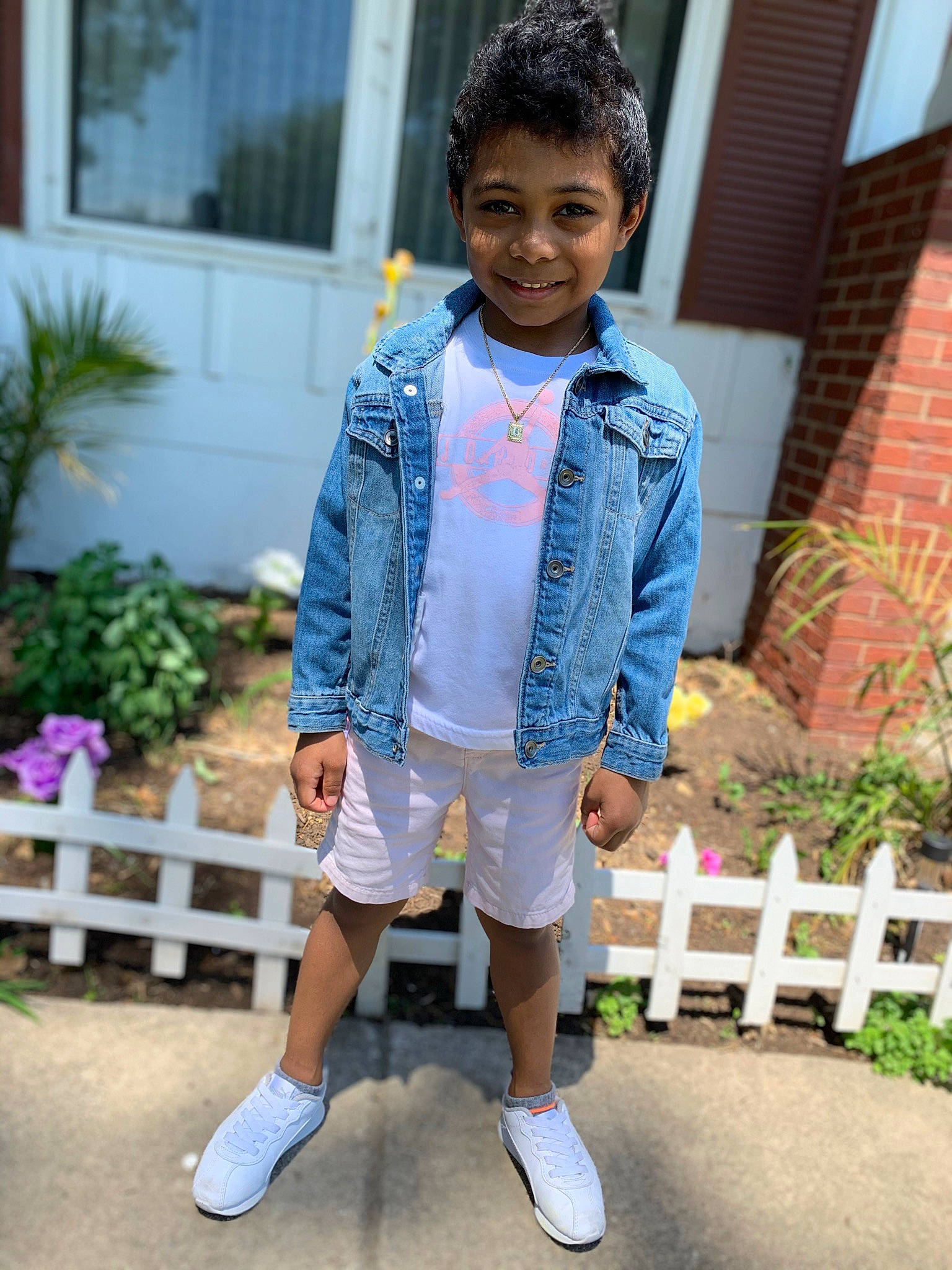 Bryson is registered to the contest to win money with this photo: child, denim, electric_blue, fence, formal_wear, hair, happy, head, joy, leisure, outerwear, person, pink, plant, shorts, sleeve, smile, sportswear, street_fashion, summer