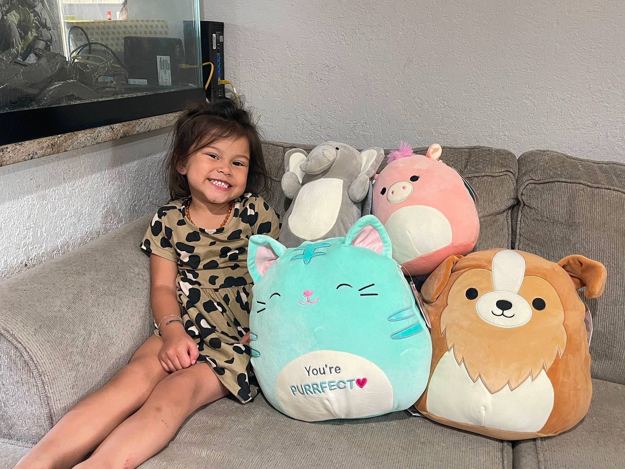 Eleanor joined the competition — help win amazing prizes! baby_toddler_clothing, comfort, couch, facial_expression, happy, joy, mammal, mouth, organ, person, picture_frame, plush, room, smile, teddy_bear, television, television_set, textile, thigh, toddler