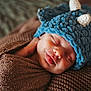 baby, newborn, sleeping, hat, knit_hat, blue_hat, blanket, brown_blanket, swaddle, cozy, portrait, closeup, peaceful, infant, sleeping_baby, adorable, tongue_out, knitted_texture, fabric, newborn_photography