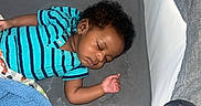 Larry is registered to the contest to win money with this photo: baby, sleeping, bassinet, blanket, blue_onesie, infant, child, carpet, indoor, peaceful, cute, resting, portrait, person, toddler, cozy, home, soft, curly_hair, sleep