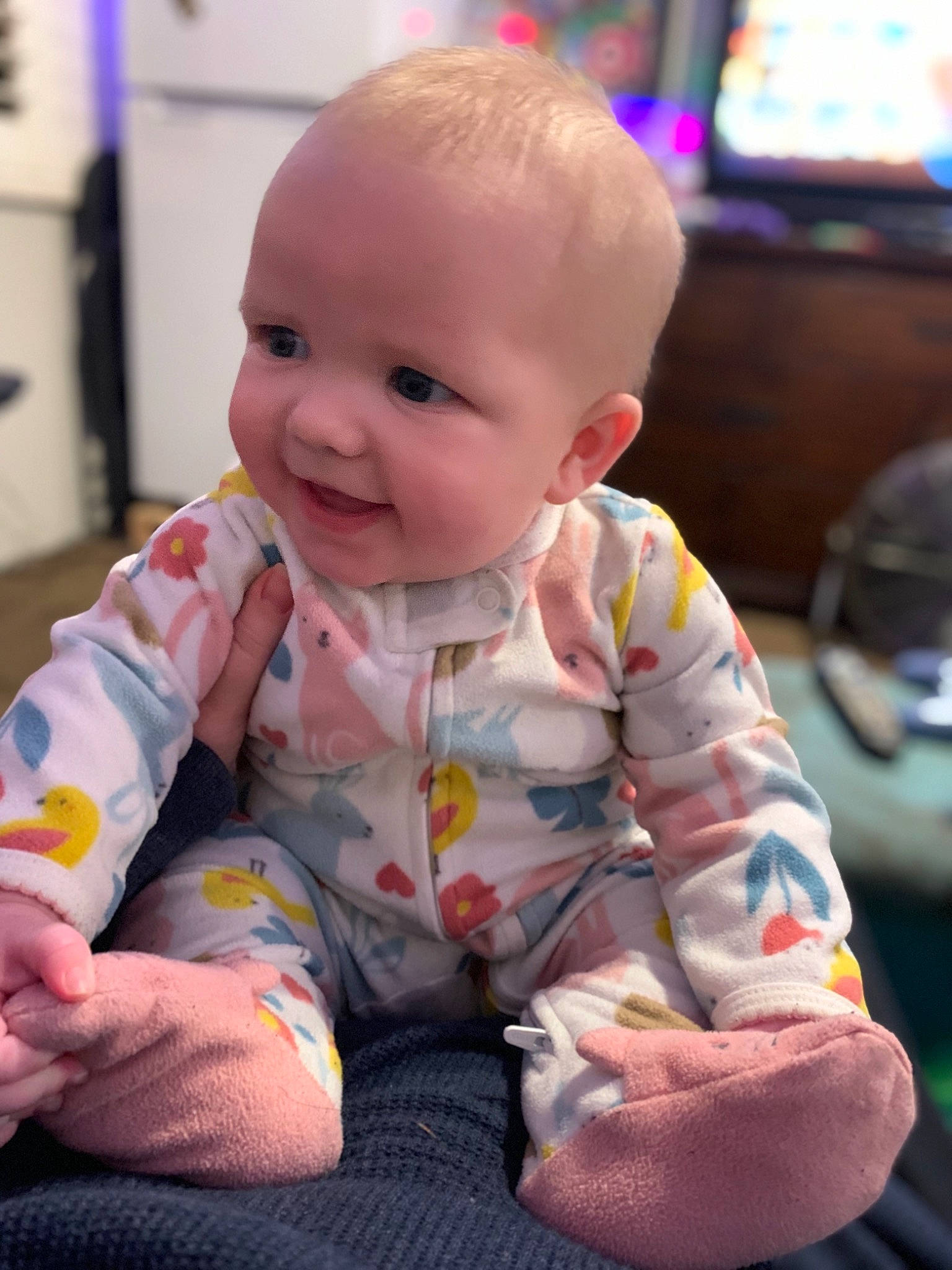 Lilly is registered to the contest to win money with this photo: baby, baby_toddler_clothing, cable_television, cheek, chin, face, facial_expression, floor, flooring, fun, head, iris, lip, mouth, nose, person, product, skin, smile, standing