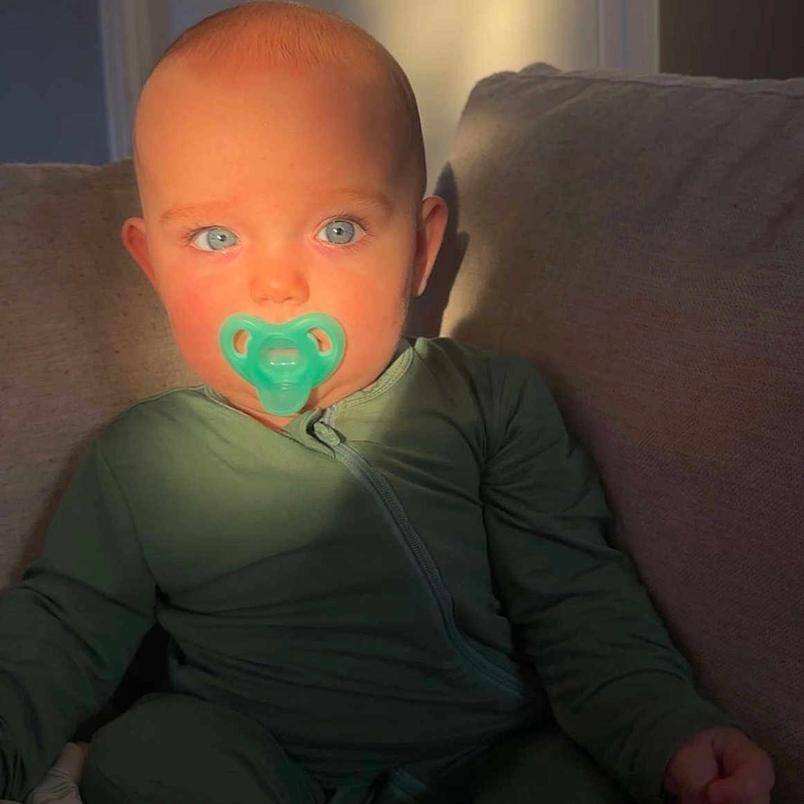 Brooks is registered to the contest to win money with this photo: baby, bodypart, clothing, coat, couch, cushion, face, finger, furniture, hand, head, homedecor, indoors, jacket, pants, person, photography, pillow, portrait, sitting