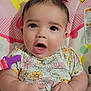 baby, child, infant, pink_bows, floral_dress, minnie_mouse, heart_shapes, baby_seat, cute, wide_eyes, expression, hands, colorful, toy_clip, patterned_clothing, indoor, portrait, happy, small_person, closeup