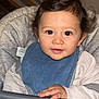 toddler, child, high_chair, bib, food_crumbs, curly_hair, indoor, baby, face, hand, table, clothing, feeding_time, cute, portrait, person, young_child, expression, looking_at_camera, seat