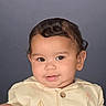baby, child, portrait, face, smiling, happy, curly_hair, brown_hair, eyes, infant, clothing, cream_outfit, button, collar, studio, gray_background, close_up, indoors, photography, adorable