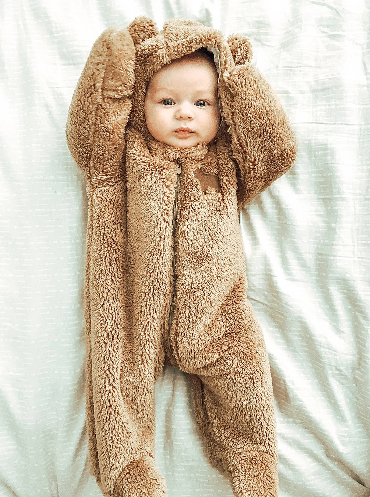 Madden is registered to the contest to win money with this photo: baby, beige, blond, brown_hair, child, child_model, clothing, face, fur, fur_clothing, head, headgear, hood, outerwear, person, product, textile, toddler, toy, wool