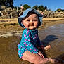 Rose participe au concours pour gagner de l'argent avec cette photo : baby, child, water, swimsuit, sunhat, beach, sand, sitting, smiling, summer, outdoor, sunny, shallow_water, nature, people, rocks, cute, portrait, happy, vacation