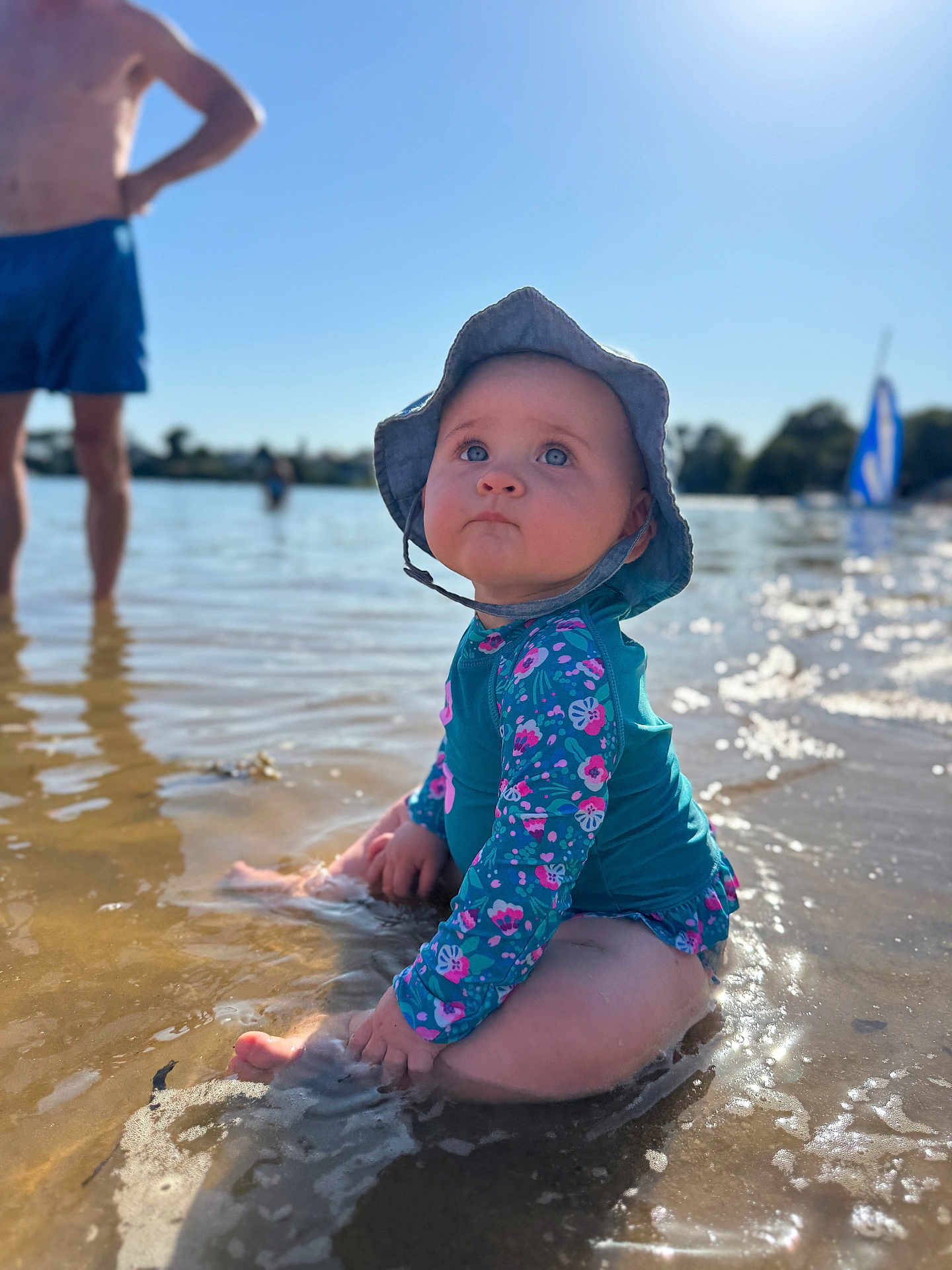 Rose participe au concours pour gagner de l'argent avec cette photo : baby, child, water, beach, sun_hat, swimsuit, sitting, sunny, outdoor, blue_sky, water_reflection, person, summer, shallow_water, nature, vacation, family, holiday, happy, daytime