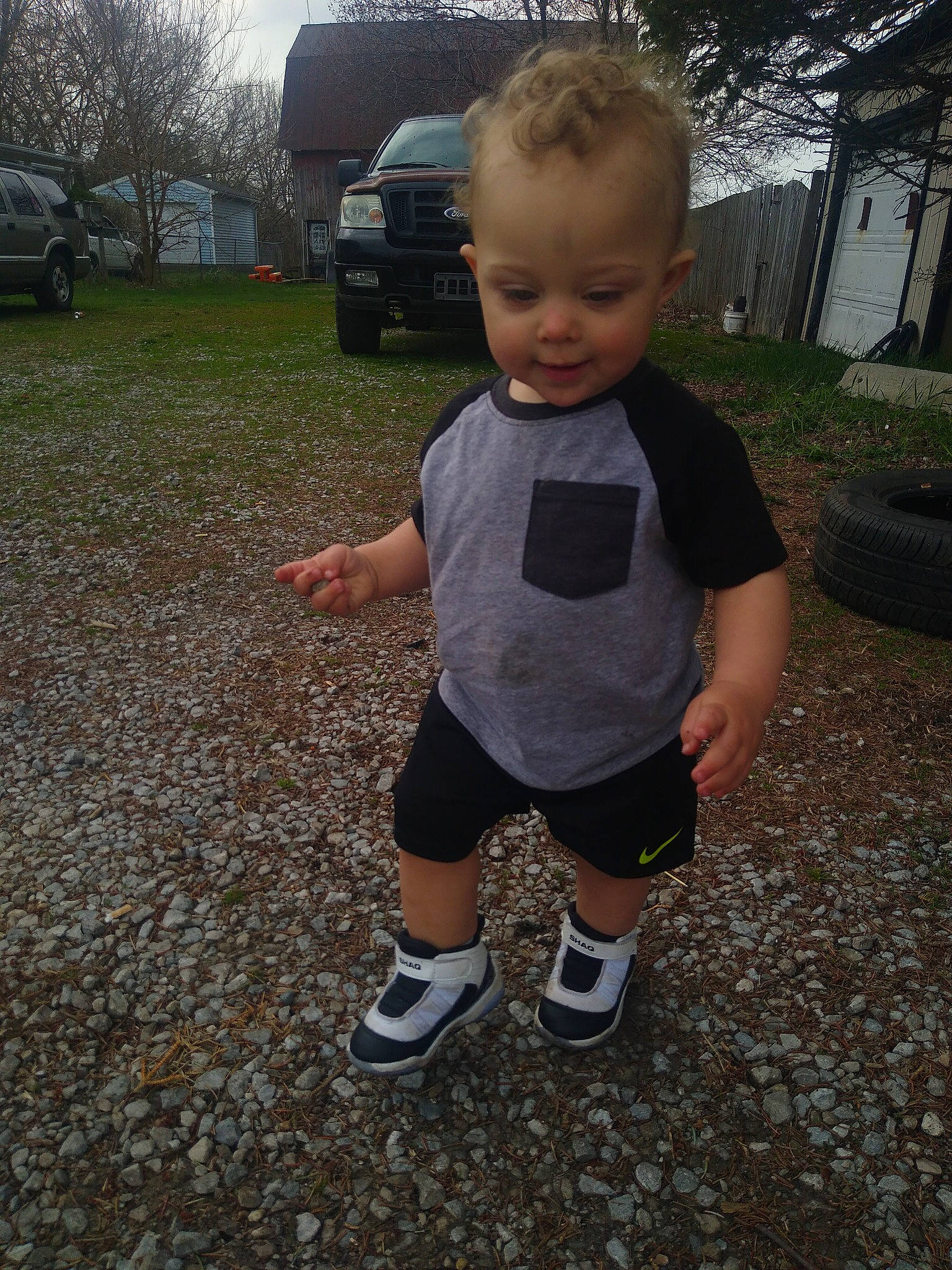 Brayson is registered to the contest to win money with this photo: asphalt, baby_toddler_clothing, car, cool, fun, grass, human_leg, knee, lawn, leisure, person, plant, shorts, sleeve, soil, sports_equipment, t_shirt, tire, toddler, tree