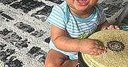 Kayden is registered to the contest to win money with this photo: baby, bongo, child, drums, face, happy, indoor, infant, living_room, musical_instrument, percussion, photography, play_walker, portrait, rug, short_hair, sitting, smiling, striped_shirt, toy