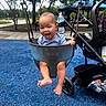 Kayden joined the competition — help win amazing prizes! baby, barefoot, blue_shirt, blue_surface, child, family_outing, happy, infant, laughing, outdoor, park, playground, playground_equipment, portrait, seated, smiling, stroller, swing, trees, water_bottle