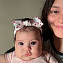 baby, infant, headband, pink_shirt, bear_design, woman, smile, face, portrait, child, holding, closeup, indoor, person, cute, expression, skin, hair, childhood, family