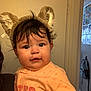 baby, child, indoor, face, cute, fuzzy_ears, orange_clothing, person, portrait, young_child, headwear, curly_hair, smiling, chubby_cheeks, door, backpack, wall, soft_lighting, casual, home