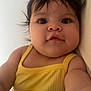 baby, child, face, portrait, yellow_clothing, sleeveless_top, dark_hair, eyes, skin, cute, infant, closeup, expression, indoors, human, person, childhood, adorable, young, smile