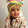 toddler, child, headband, colorful, bow, jacket, quilted_jacket, floral_pattern, indoor, curious_eyes, cute, baby, person, portrait, warm_clothing, fashion, expression, face, hair, standing