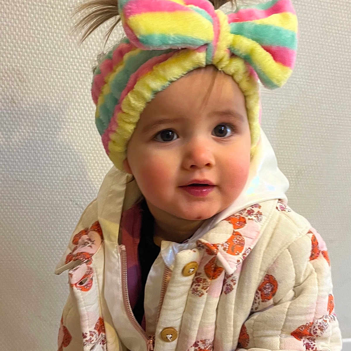 Andriana participe au concours pour gagner de l'argent avec cette photo : baby, bow, child, colorful, curious_eyes, cute, expression, face, fashion, floral_pattern, hair, headband, indoor, jacket, person, portrait, quilted_jacket, standing, toddler, warm_clothing