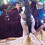 cat, calico_cat, christmas_tree, ornament, holiday_lights, tree_branch, curious, indoor, decorations, pet, festive, twinkling_lights, holiday, tree_skirt, animal, whiskers, collar, cozy, background, curiosity