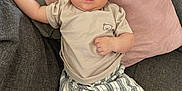 Jaden participe au concours pour gagner de l'argent avec cette photo : baby, infant, child, couch, pillow, clothing, striped_pants, beige_tshirt, face, barefoot, indoor, floor_tiles, baby_bottle, relaxed, portrait, person, home, cute, skin, furniture