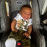 Jayceon is registered to the contest to win money with this photo: baby, child, infant, smiling, portrait, car_seat, indoors, clothing, camouflage, teddy_bear, white_shirt, sneakers, sock, foot, seated, happy, face, vehicle, safety_harness, photography