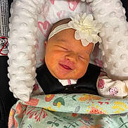 Scarlett is registered to the contest to win money with this photo: animal_print, baby, blanket, car_seat, child, clothing, comfort, cushion, cute, face, floral_print, flower, headband, heart_pattern, indoors, infant, newborn, sleeping, smiling, soft_texture