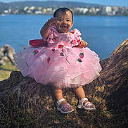Karoline is registered to the contest to win money with this photo: baby, blue_sky, child, cute, fashion, footwear, grass, happy, lake, nature, outdoor, people, pink_dress, portrait, sandals, smiling, summer, sunlight, tree_root, water